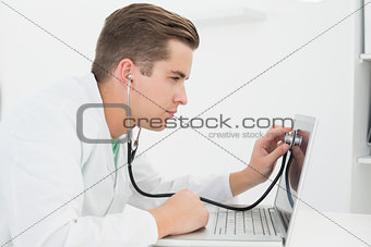 Technician listening to laptop with stethoscope