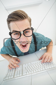 Casual angry businessman typing at his desk