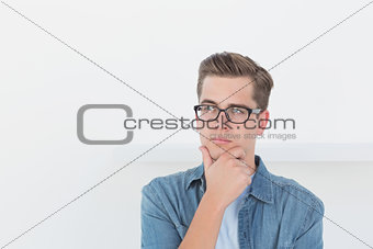 Nerdy casual businessman thinking with hand on chin