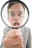 Excited businessman looking through magnifying glass