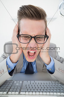 Angry businessman working on computer
