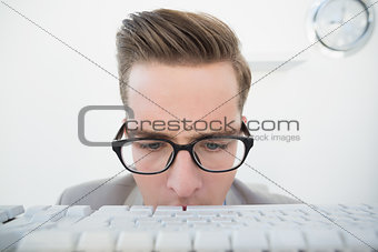 Nerdy businessman looking at keyboard