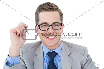 Nerdy businessman holding pen smiling at camera