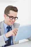 Nerdy businessman working on tablet pc