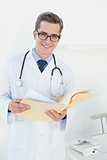 Young handsome doctor reading file