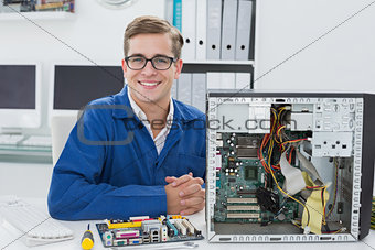 Smiling technician working on broken computer