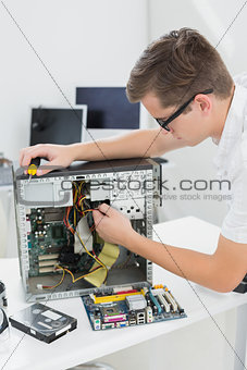 Young technician working on broken computer