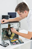 Young technician working on broken computer