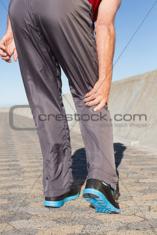 Active senior man touching his injured knee
