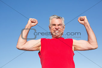 Active senior man cheering in red tank top