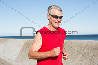 Active senior man jogging on the pier