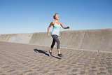 Active senior woman jogging on the pier