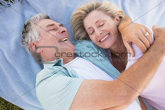 Happy senior couple cuddling on blanket