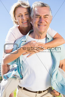 Happy senior man giving his partner a piggy back