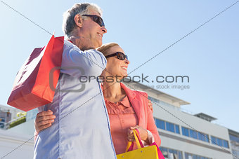 Happy senior couple holding shopping bags