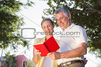 Happy senior couple using the guidebook