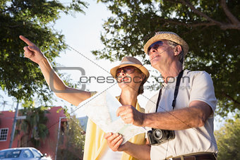 Happy senior couple using the map and looking