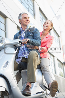 Happy senior couple riding a moped