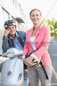 Happy senior couple posing with their moped