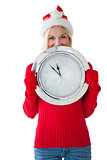 Festive blonde holding large clock