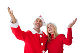 Festive couple standing with arms raised