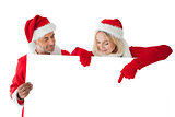 Festive couple pointing to large white card