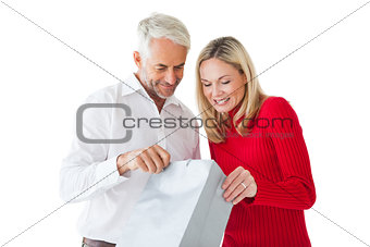 Smiling couple looking into shopping bag