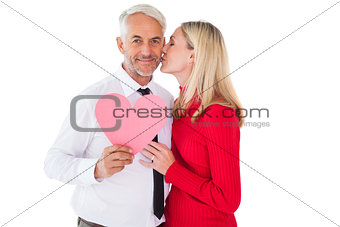 Handsome man holding paper heart getting a kiss from wife
