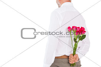 Man holding bouquet of roses behind back