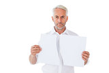 Serious man holding torn sheet of paper