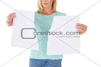 Serious woman holding torn sheet of paper