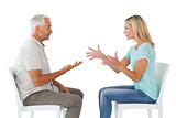 Unhappy couple sitting on chairs having an argument