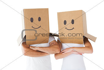 Couple wearing smiley face boxes on their heads