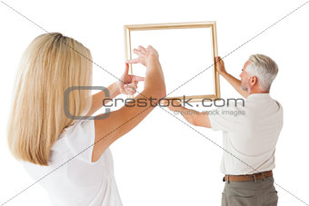 Couple hanging a frame together