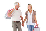 Happy couple holding shopping bags and hands