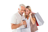 Happy couple holding shopping bags and smartphone
