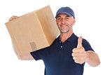 Happy delivery man holding cardboard box showing thumbs up