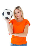 Football fan holding ball in orange tshirt