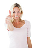 Happy blonde showing thumbs up and smiling at camera