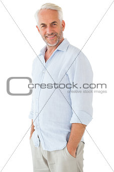 Smiling man posing with hands in pockets