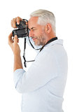 Smiling man taking a photo on digital camera