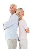 Smiling couple standing leaning backs together
