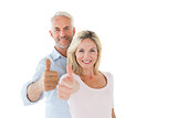 Smiling couple showing thumbs up together