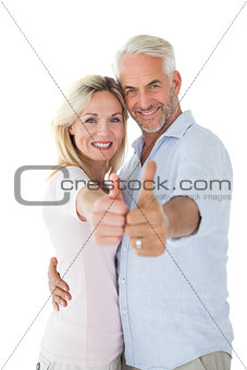 Smiling couple showing thumbs up together