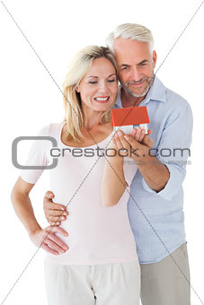Happy couple holding miniature model house