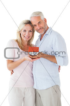 Happy couple holding miniature model house