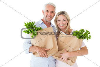 Happy couple carrying paper grocery bags