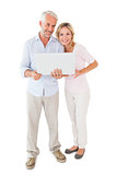 Happy couple standing and using laptop together