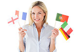 Smiling blonde woman holding european flags