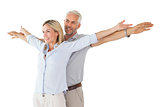 Happy couple standing with arms outstretched